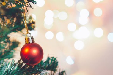 Noel süsü. Çam dallarında asılı kırmızı toplar Noel ağacı çelengi ve soyut bokeh arkaplanının üzerinde fotokopi alanı olan süsler
