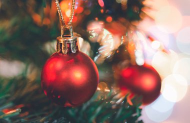 Noel süsü. Çam dallarında asılı kırmızı toplar Noel ağacı çelengi ve soyut bokeh arkaplanının üzerinde fotokopi alanı olan süsler