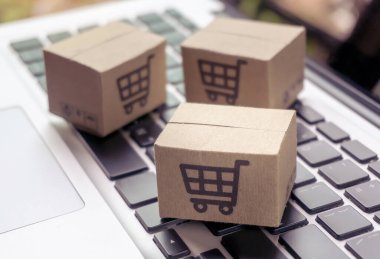 İnternetten alışveriş, kağıt kutular ya da klavyede alışveriş arabası logosu olan bir paket. İnternet üzerinden alışveriş hizmeti sunuyor..