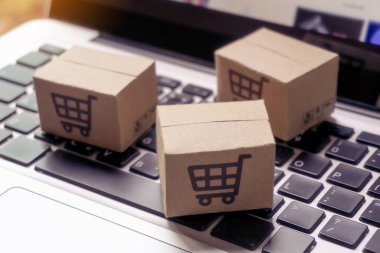 İnternetten alışveriş, kağıt kutular ya da klavyede alışveriş arabası logosu olan bir paket. İnternet üzerinden alışveriş hizmeti sunuyor..
