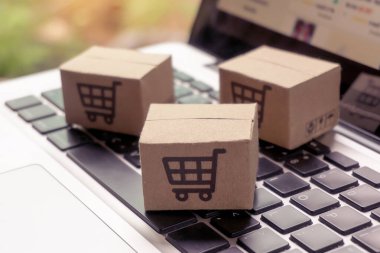 İnternetten alışveriş, kağıt kutular ya da klavyede alışveriş arabası logosu olan bir paket. İnternet üzerinden alışveriş hizmeti sunuyor..