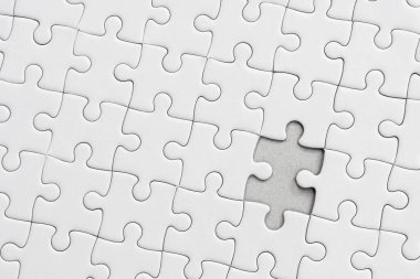 Beyaz yapboz desenli arka plan. Yapbozun son parçasını yerleştiriyorum.