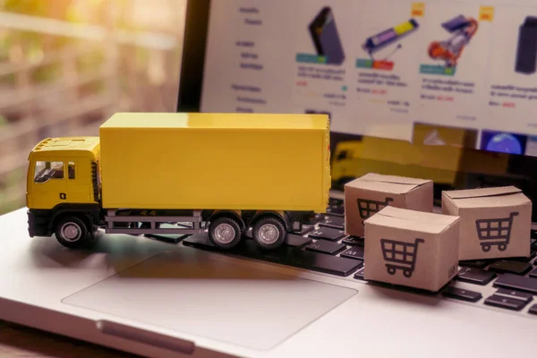 Logistics, and delivery service - Truck and paper cartons or parcel with a shopping cart logo on a laptop keyboard. Shopping service on The online web and offers home delivery.