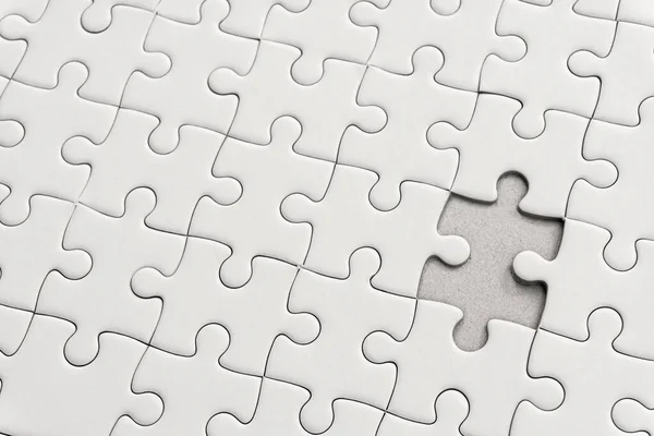 White jigsaw puzzle pattern background. placing last piece of jigsaw puzzl