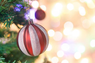 Noel süsü. Çam dallarında asılı kırmızı toplar Noel ağacı çelengi ve soyut bokeh arkaplanının üzerinde fotokopi alanı olan süsler