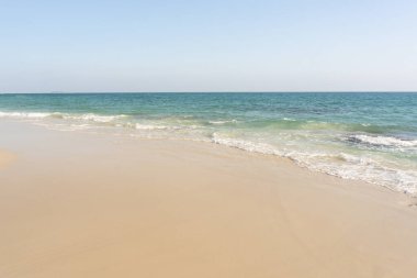 Plaj ve dalgalar güneşli bir arka planda mavi gökyüzü ile tropikal deniz. Boşluğu kopyala