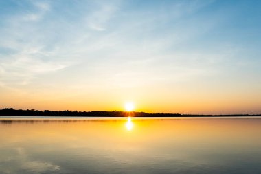 Gölde gün batımı, deniz manzarasının üstünde güzel bir gün batımı.