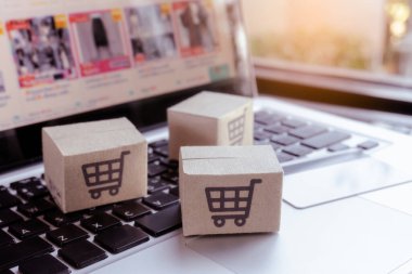İnternetten alışveriş. Kredi kartı ve klavyede alışveriş arabasının logosu olan karton kutu. İnternet 'te alışveriş servisi. Eve teslim etmeyi teklif ediyor