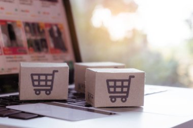 İnternetten alışveriş. Kredi kartı ve klavyede alışveriş arabasının logosu olan karton kutu. İnternet 'te alışveriş servisi. Eve teslim etmeyi teklif ediyor