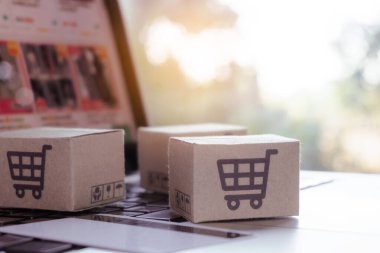 İnternetten alışveriş. Kredi kartı ve klavyede alışveriş arabasının logosu olan karton kutu. İnternet 'te alışveriş servisi. Eve teslim etmeyi teklif ediyor
