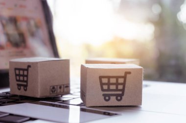 İnternetten alışveriş. Kredi kartı ve klavyede alışveriş arabasının logosu olan karton kutu. İnternet 'te alışveriş servisi. Eve teslim etmeyi teklif ediyor