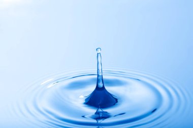 Bir damla su. Su damlası su yüzeyine çarpıyor. Su yüzeyinde halka oluşturur.