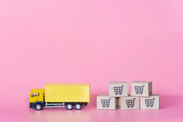 Logistics, and delivery service - Cargo truck and paper cartons or parcel with a shopping cart logo on Pink background. Shopping service on The online web and offers home delivery.