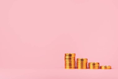 Para biriktirme ve yatırım konsepti. Bozuk paraların üzerinde duran ahşap evler. kopyalama alanı olan pembe arkaplan üzerinde