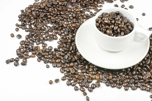 Kávová zrna v izolovaných na bílém šálek kávy — Stock fotografie
