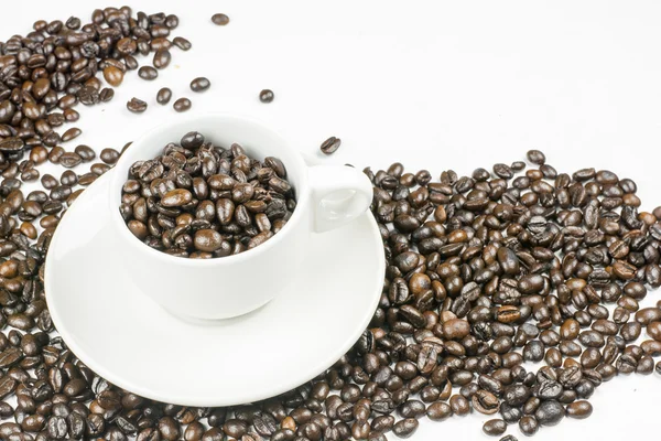 Granos de café en taza de café aislado en blanco — Foto de Stock