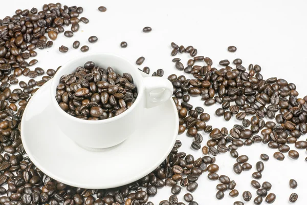 Grains de café dans une tasse de café isolé sur blanc — Photo