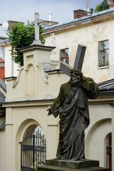 Antika statyn av Kristus bär korset, i gården av den armeniska kyrkan i Lviv. — Stockfoto