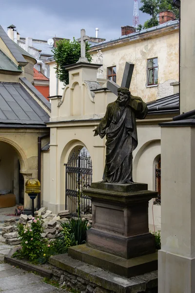Ancienne statue du Christ portant la croix, dans la cour de l'église arménienne de Lviv . — Photo