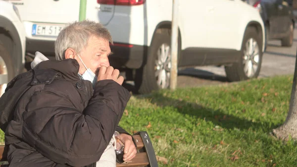 LECCO-ITALY - 31 Ekim 2020: Lecco şehrinde olgun bir adam bir şeyler yiyor.