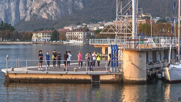 LECCO-ITALY - 31 10月2020:コモ湖のドックで体操をする若者 — ストック写真