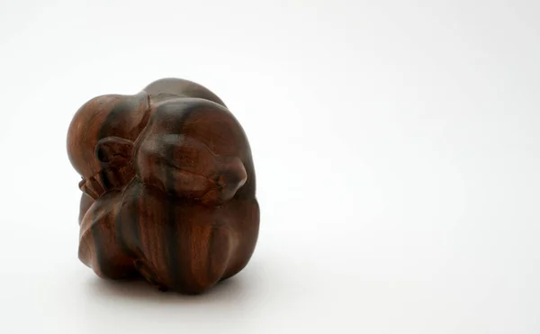 Tahta Buda heykeli yan görünümü. Beyaz arka planda ağlayan Buda