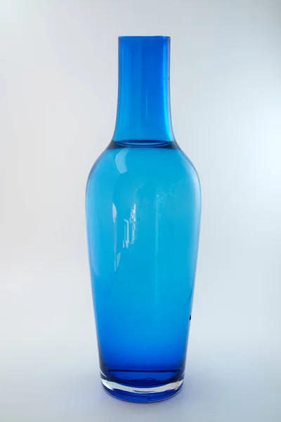 Mavi şişe beyaz arka planda izole edilmiş.