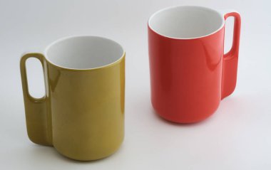 Beyaz arka planda yeşil ve kırmızı bir seramik çay fincanı. Kapat..