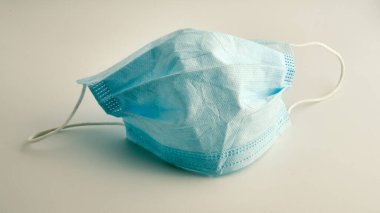 Beyaz arka planda yeşil tıbbi maske ve korona virüsü koruması