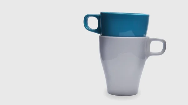 Beyaz arka planda beyaz ve mavi seramik kupası