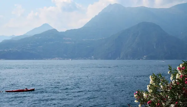 Varenna panorámája a Comói-tavon zöld dombokkal és hegyekkel a háttérben. — Stock Fotó