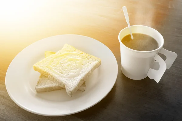 Café quente e pão tostado coberto com leite doce para o café da manhã eo sol da manhã tocado (conceito saudável ) — Fotografia de Stock