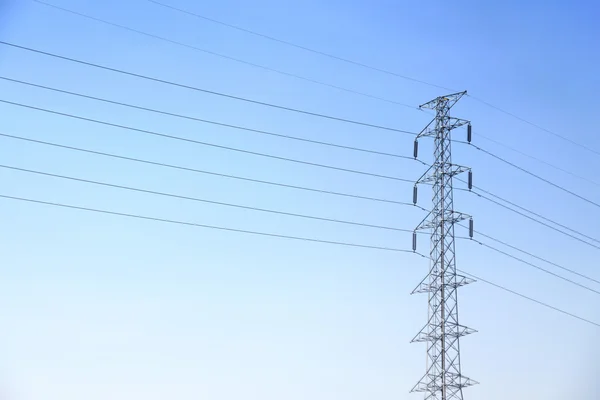 Poste de alta tensión o torre de línea de transmisión de energía y cielo azul —  Fotos de Stock