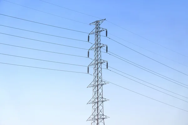 Poste de alta tensión o torre de línea de transmisión de energía y cielo azul —  Fotos de Stock