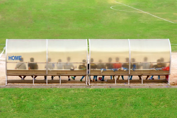 Soccer players and staff sit on bench beside the soccer field (Home team) — Stock Photo, Image