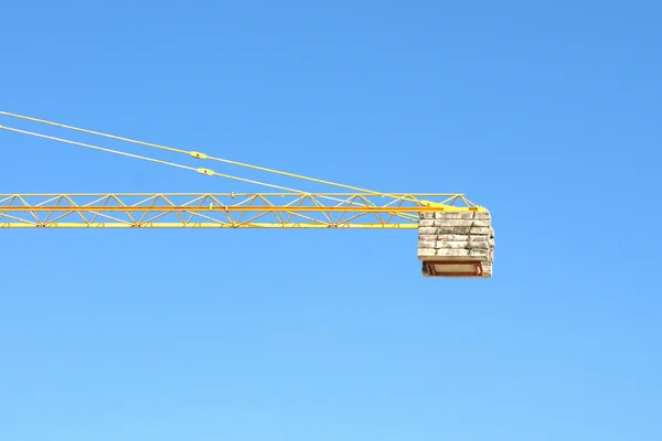 Grúa industrial amarilla y cielo azul en obra o puerto marítimo — Foto de Stock