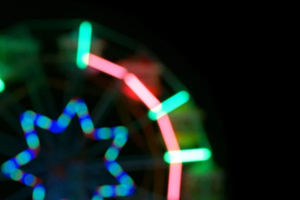 Imagen desenfocada y borrosa de la rueda del hurón en el parque de atracciones por la noche — Foto de Stock