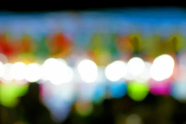 Defocused and blurred image of people at amusement park at night — Stock Photo, Image