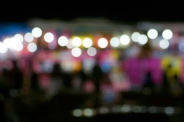 Defocused and blurred image of people at amusement park at night — Stock Photo, Image