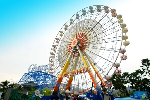 De kleurrijke reuzenrad in attractiepark met blauwe lucht. — Stockfoto