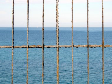 Denizin önünde paslı çit.