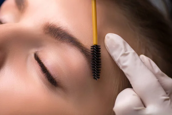 Permanent eyebrow makeup. Cosmetologist applying tattooing of eyebrows