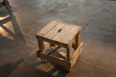 Yere eski el yapımı tabure.