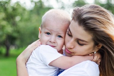 Küçük oğlunu kucaklayan mutlu bir anne.