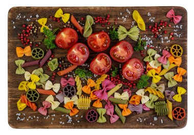 Eski, karanlık, kırsal, çatlak, kesme tahtasındaki malzemeler beyaz arka planda. İtalyan yemek geçmişi. Yemek malzemesi. Sağlıklı gıda hazırlama konsepti. Domatesli vejetaryen yemeği, maydanoz, biber ve makarna..