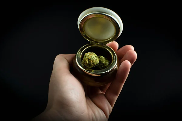 Erva. Cannabis Buds em um jarro de cerâmica isolado sobre fundo preto — Fotografia de Stock