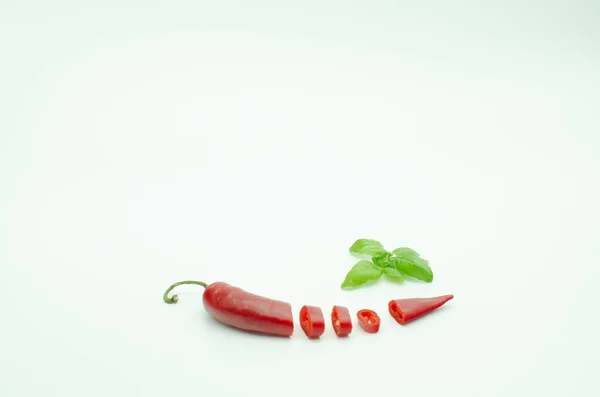 Red Hot Chili Papper izolované na bílém. Pikantní paprika nakrájená. Zelená bazalka. Vaření koření — Stock fotografie