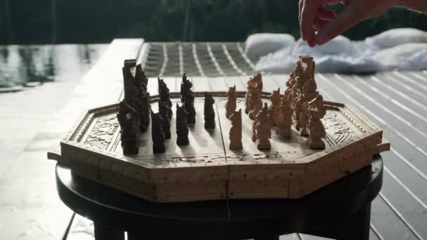 プールの近くで手作りのチェスを保持マン手 — ストック動画