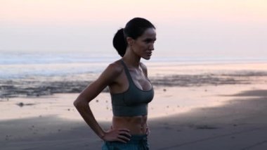 Sahildeki eğitimden sonra yorgun bir kız kameraya bakıyor.