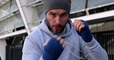 Şehir caddesinde boksör antrenman yumruğu. Portre dövüşçüsü erkek boks sahası.